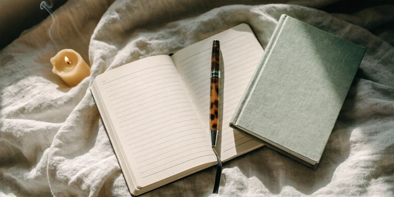 Notitieboek met vulpen, kaars en boek op linnen — Breaking the Habit of Being Yourself van Joe Dispenza